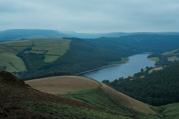 a view of a ladybower reservoir in the Peak District UK a large body of water with a mountain in the background