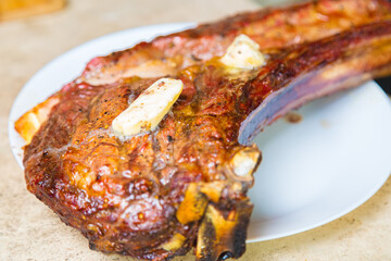 Cooked fried meat with spices on a white plate. Oven-baked meat for dinner with a glass of red wine.