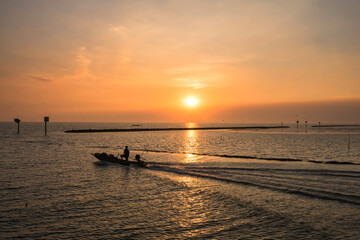 Fototapeta na wymiar Silhouette fisherman sailing fishing boat at sunset