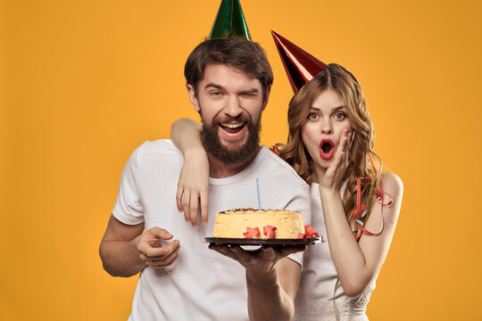 cheerful young couple with caps on their heads birthday holiday party