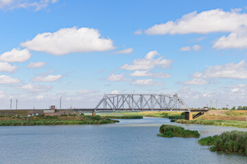 A small railway bridge across the river on a summer day