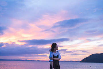 Fototapeta premium 夕暮れの海にいる女性