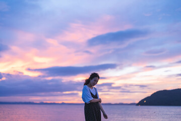 夕暮れの海にいる女性