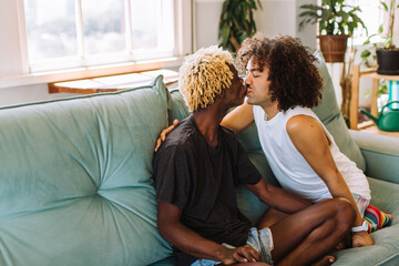 Passionate gay couple sharing a kiss at home