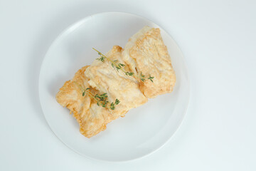 fillet of fish in batter on white plate closeup isolated on white background.