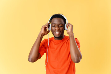 Fototapeta premium man in orange t-shirt with headphones listening to music