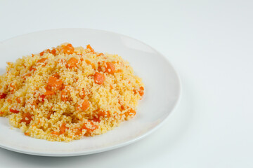 couscous with carrots in white plate closeup. couccous isolated on white background