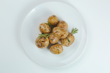baked baby potatoe closeup on white plate. Roasted or baked baby potatoes with oil and herbs with...