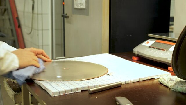 Vinyl record factory: Removing metal layer from the lacquer creating a metal stamper to press from.