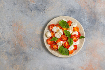Delicious Italian Caprese salad with sliced red and orange cherry tomatoes.