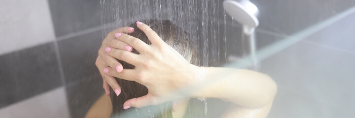 Woman takes hot shower in bathroom closeup