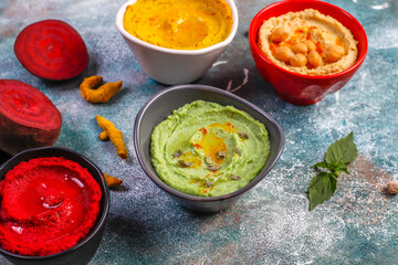 Traditional Middle eastern food various hummus. Green,yellow,beet and traditional hummus in small bowls.
