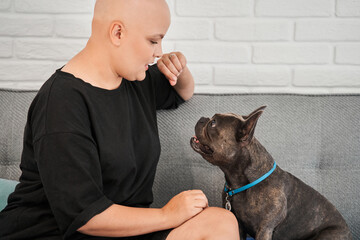 Woman praises her dog for good command execution while looking at him with tenderness