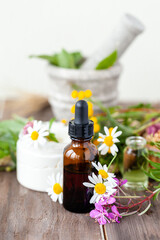 Concept of herbal, flower extracts in cosmetics. Natural organic ingredients, pure extract for beautiful healthy skin, essential oil, aromatherapy. Wooden background, close up