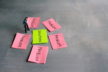 Business solutions, problem solving and brainstorming concept. Miniature man looking at red paper...