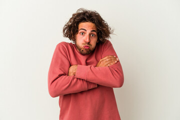 Young caucasian man isolated on white background shrugs shoulders and open eyes confused.