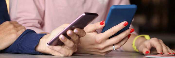 Two people are holding smartphones in their hands closeup
