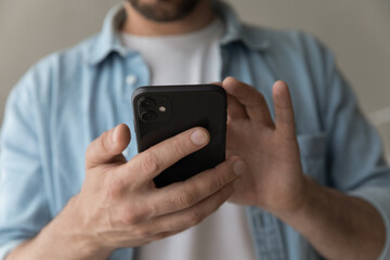 Close up view male hands holding modern cell phone chatting with friend through social media network or messenger, businessman dialling number makes business call. New mobile application usage concept