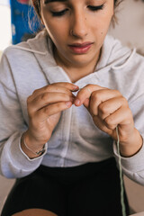 teenage girl learning to sew with green thread