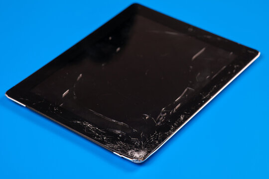 Rostov-on-Don / Russia - July 23 2021: Tablet Computer Apple IPad With Broken Screen Glass, The Result Of Falling Or Crash. Vibrant Blue Background, Copy Space.