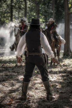 The confrontation of sheriff with two bank robbers that are on riding horse but meet sheriff before escape and are preparing for a gun fight. Cowboy concept.