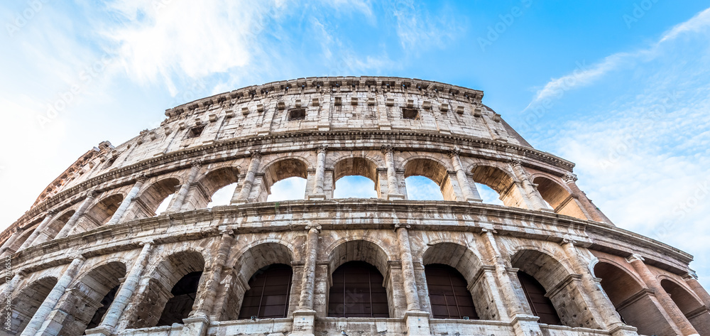 Wall mural colosseum in rome (roma), italy. the most famous italian sightseeing on blue sky