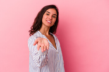 Obraz premium Young caucasian woman isolated on pink background stretching hand at camera in greeting gesture.
