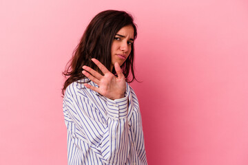 Young caucasian woman isolated on pink background rejecting someone showing a gesture of disgust.