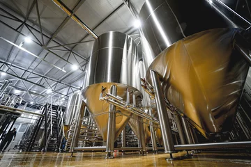 Fotobehang Rows of steel tanks for beer fermentation and maturation in a craft brewery © romaset