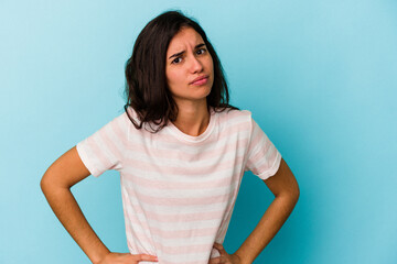 Young caucasian woman isolated on blue background confused, feels doubtful and unsure.