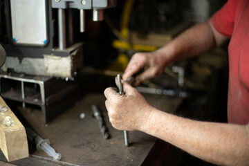 A man pulls out a drill. Installing a drill for a drill. Works in the garage.