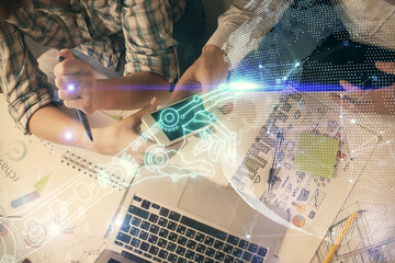 Double exposure of tech theme hologram and man and woman working together holding and using a mobile device.