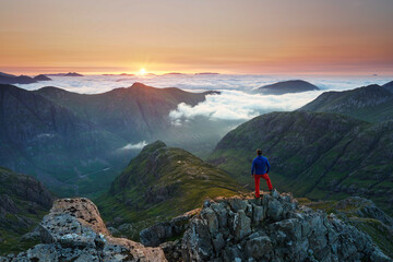 Unrecognizable Tourist taking in a sunrise view over the three sisters mountains, Glencoe,...