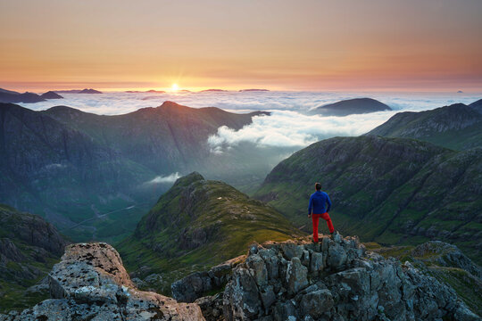 Unrecognizable Tourist taking in a sunrise view over the three sisters mountains, Glencoe, Highlands, Scotland.