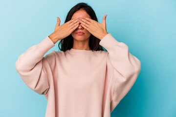 Young caucasian woman isolated on blue background afraid covering eyes with hands.