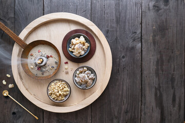 Burning incense - incense resin Arabia Aden, Yemen and Oman on wooden plate with charcoal, spoon and feather from above,  copy space