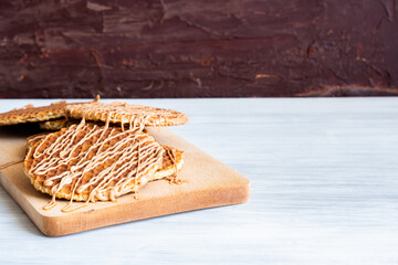 Traditional Stroopwafel local authentic sweet dessert Dutch Netherlands sweet fresh homemade tasty stack brown golden waffle melt salted caramel honey syrup for cafe with hot warm coffee milk tea 