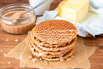 Traditional Stroopwafel local authentic sweet dessert Dutch Netherlands sweet fresh homemade tasty stack brown golden waffle melt salted caramel honey syrup for cafe with hot warm coffee milk tea 
