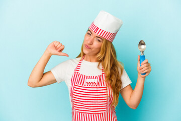 Caucasian ice cream maker woman holding an ice cream scoop isolated on blue background feels proud and self confident, example to follow.