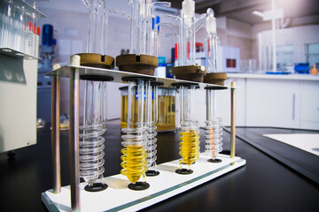 Test tube chemistry flask with yellow liquid purified oil from recycling and lubricating materials...