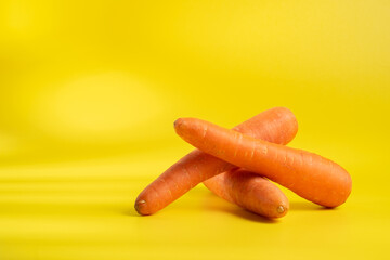 Three carrots on a yellow background
