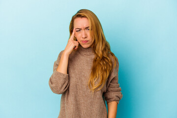 Caucasian woman isolated on blue background pointing temple with finger, thinking, focused on a task.