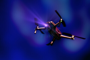 A flying drone. Airborne quadcopter. Also known as a drone or UAV, Unmanned Aerial Vehicle. Drone with camera on a colorful background with copy space.