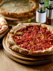 Pizza bread with pepperoni meat and red tomatoes sauce with other Italian traditional pizza assorted mix on  restaurant background 