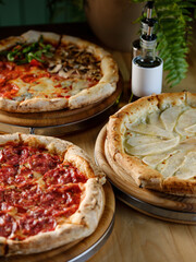 Pizza bread with pepperoni meat and red tomatoes sauce with other Italian traditional pizza assorted mix on  restaurant background 