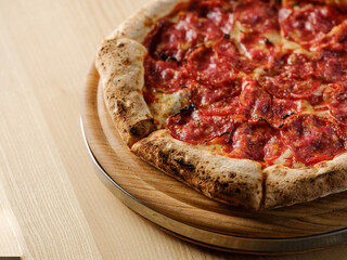 Pizza bread with pepperoni meat and red tomatoes sauce with other Italian traditional pizza assorted mix on  restaurant background 