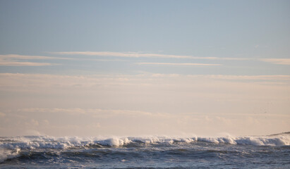 Beautiful sunset with crashing ocean waves in the foreground.