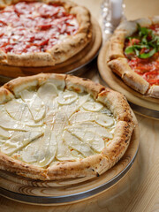Sweet pizza baked with fruits, mix of cheese, honey, sauce and Italian traditional bread dough recipe in farm fire oven. Top view on wooden table background
