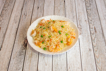 Chinese rice dish three delicacies with many cooked prawns on white plate