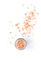 Himalayan pink salt in glass jar isolated on white background, top view